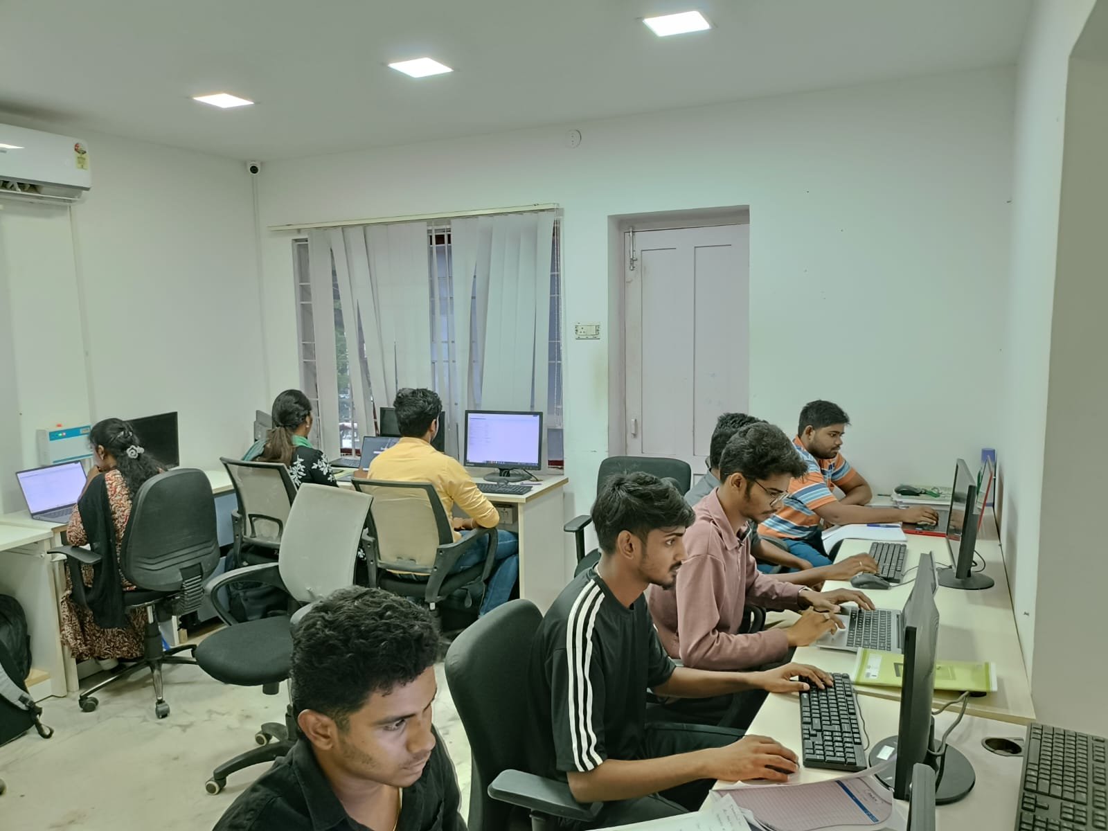 Students working hands-on at computer workstations during a live batch at a Techmaax centre